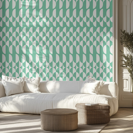 Living room with a white sofa, wicker ottomans, with teal and white geometric wallpaper.