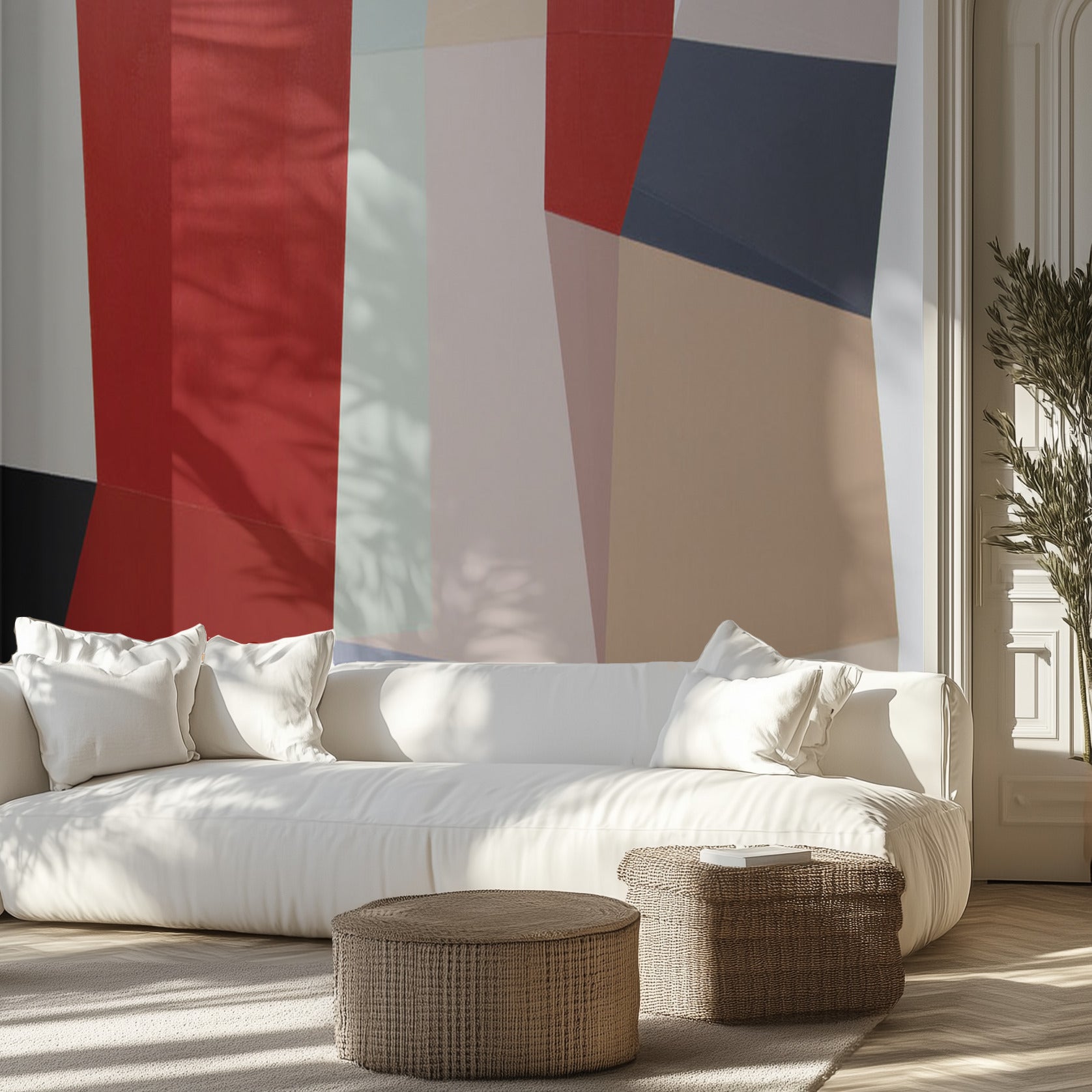 Modern living room with a white sofa, wicker ottomans, and an abstract geometric wall mural.