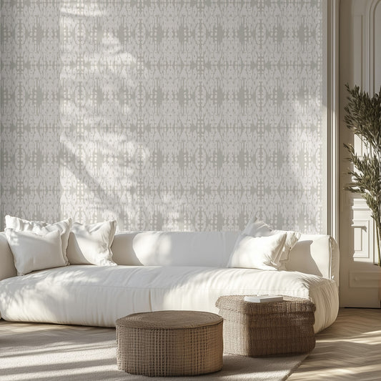 White sofa with decorative pillows in a room with soft white and soft muted sage green boho patterned wallpaper and wooden floor.