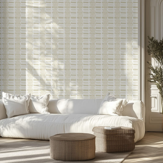 White sofa with decorative pillows in a room with textured organic neutral wallpaper and wooden floor.