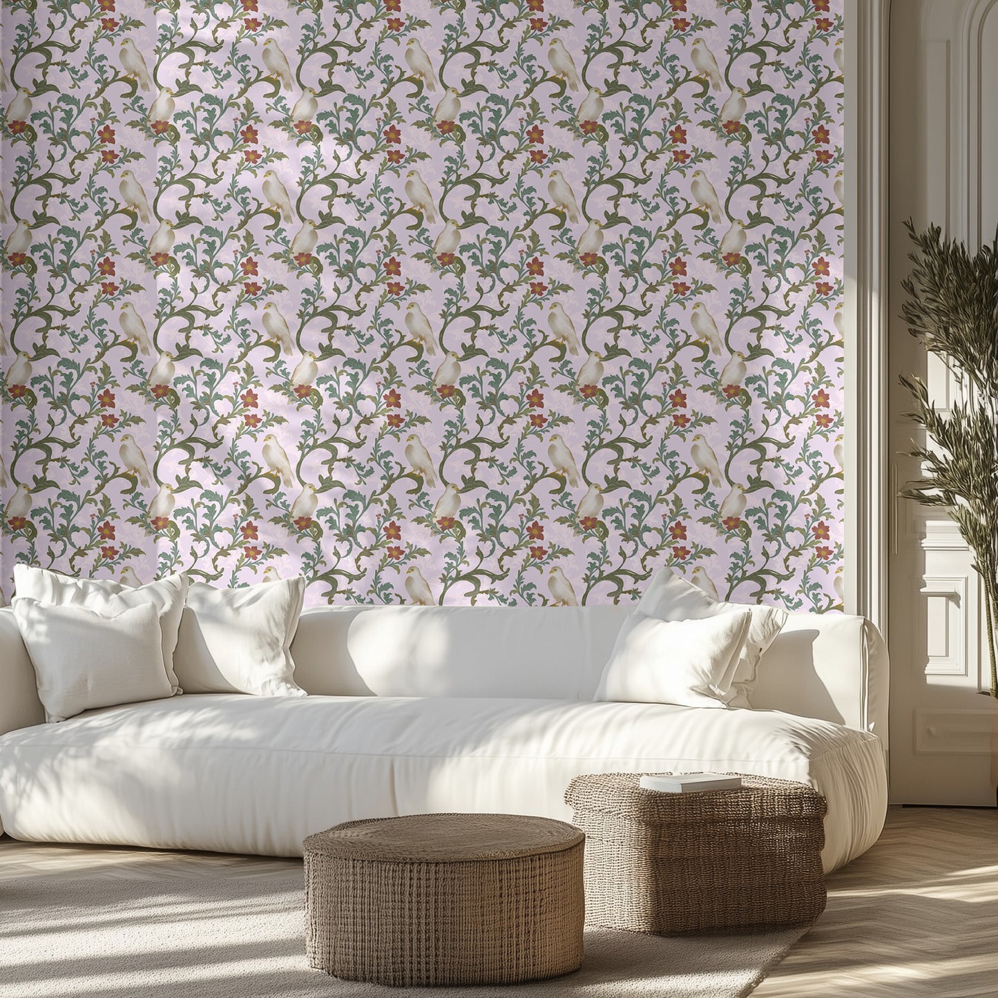 Living room with a white sofa, dove and vine patterned wallpaper, and wicker ottomans.