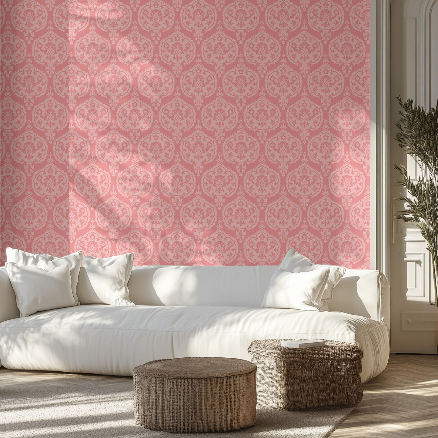 Living room with a white sofa, pink damask wallpaper on the wall, and wicker ottomans.