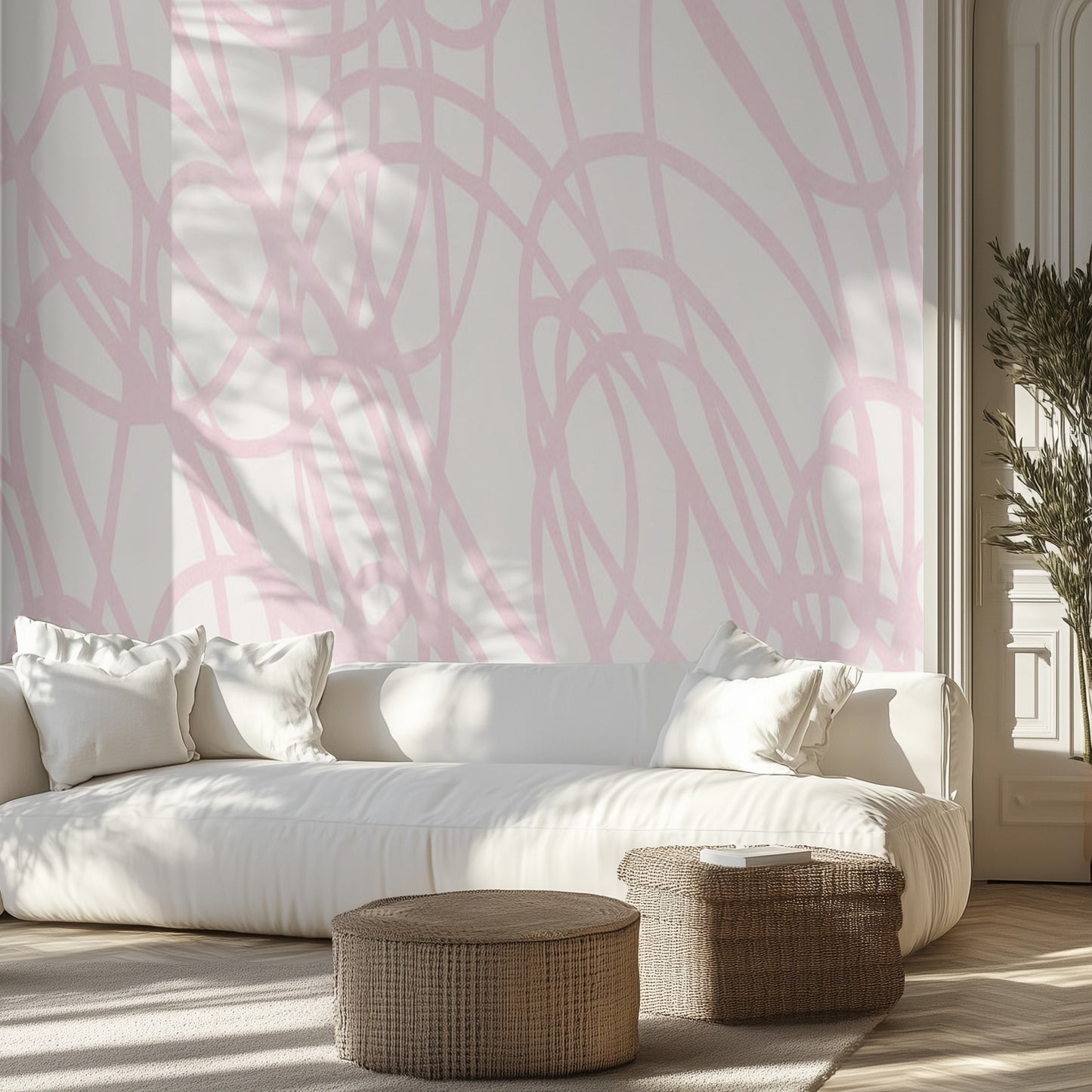 Living room with white sofa, pink abstract lines wall mural, and wicker ottomans.