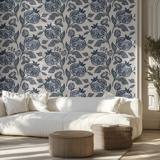 Living room with white sofa, blue pomegranate patterned wallpaper, and decorative ottomans.