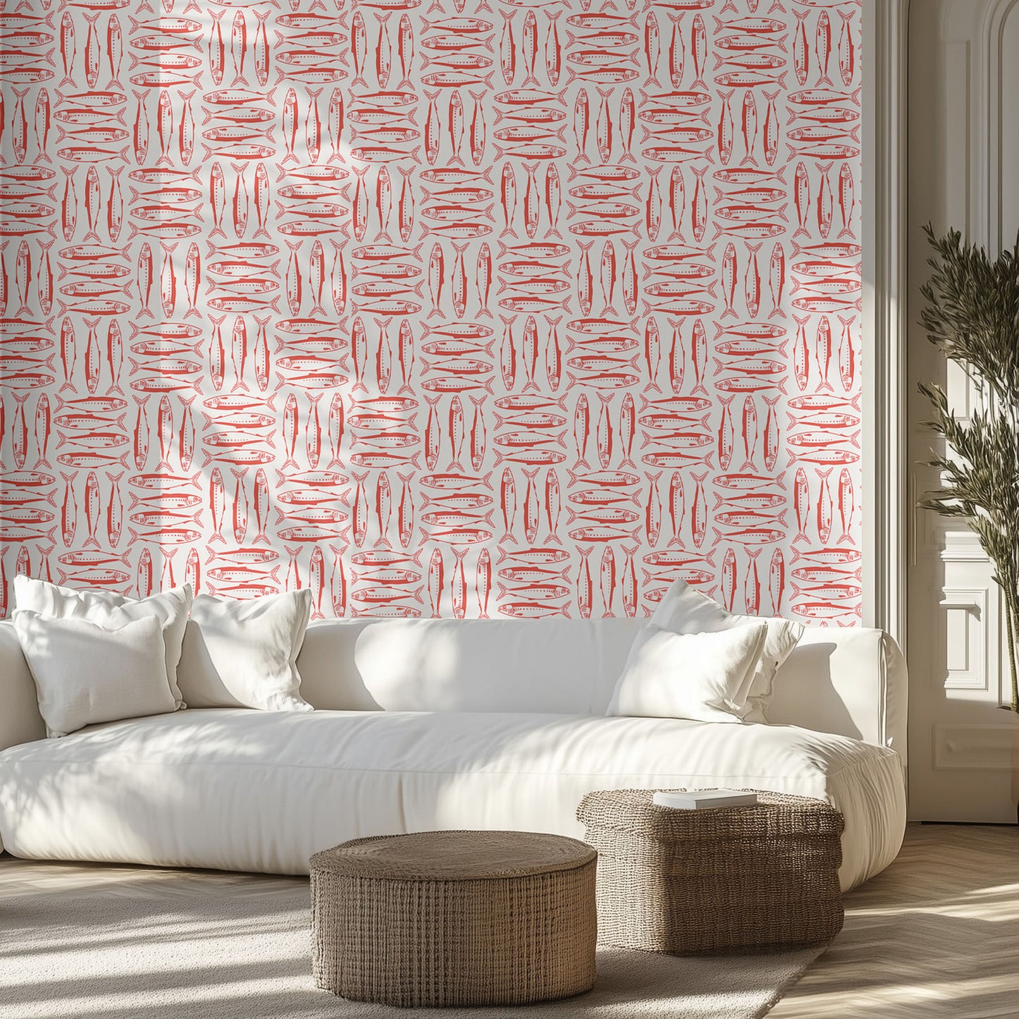 Modern living room with a white sofa, coastal red sardine patterned wallpaper, and wicker ottomans.