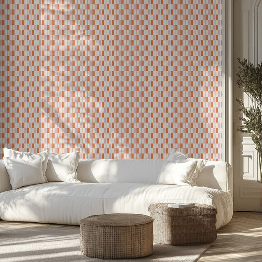 Living room with white sofa, pink and orange midcentury patterned wallpaper, and wicker ottomans.