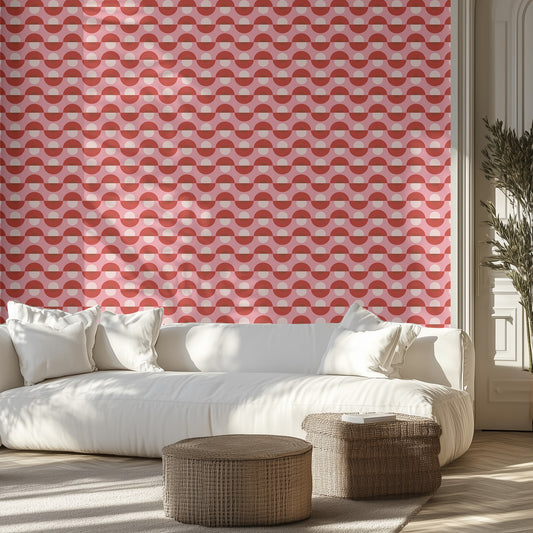 Living room with a white sofa, wicker ottomans, and a pink geometric patterned wall.