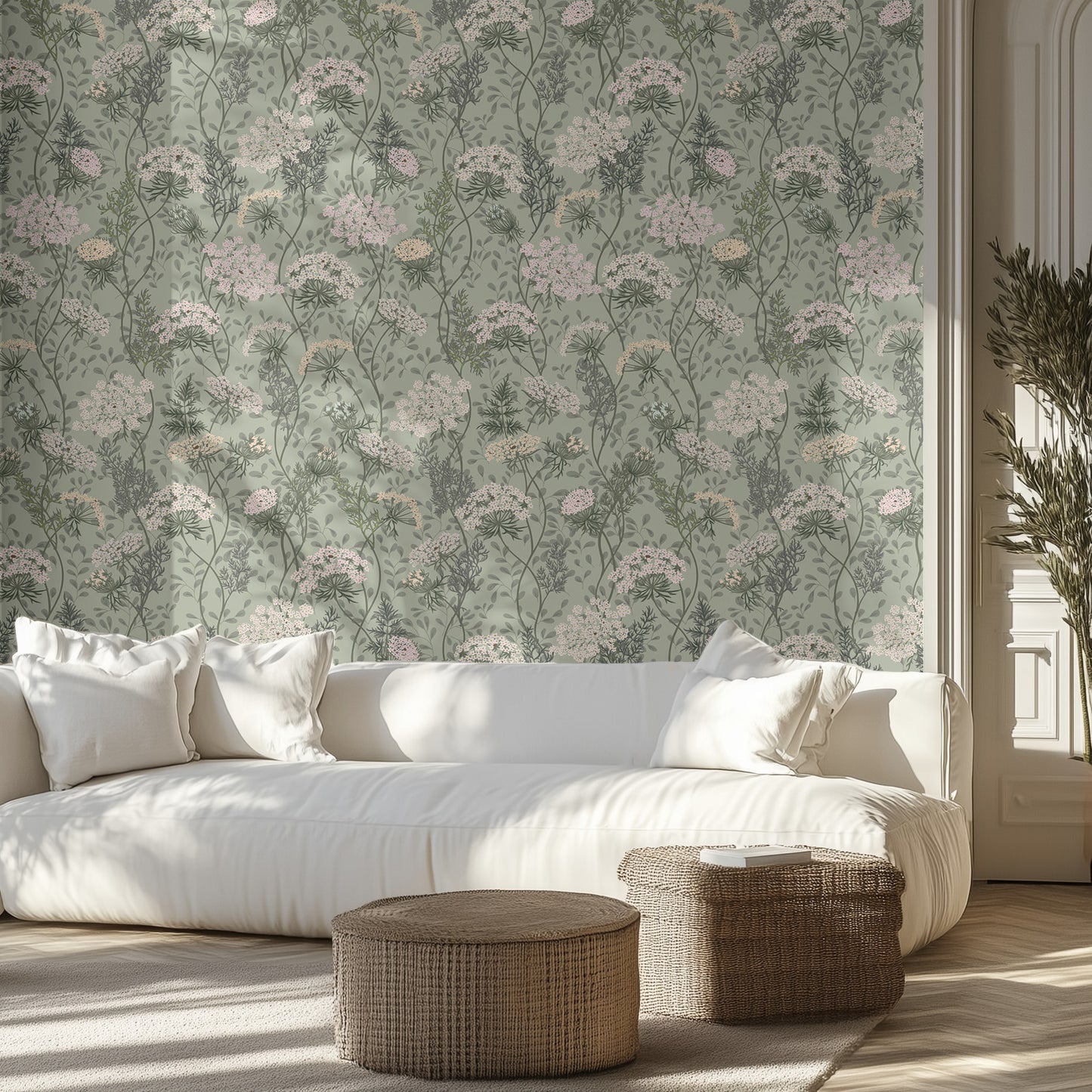 Modern living room with a white sofa, wicker ottomans, and sage floral textured wall.