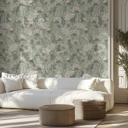 Modern living room with a white sofa, wicker ottomans, and sage floral textured wall.