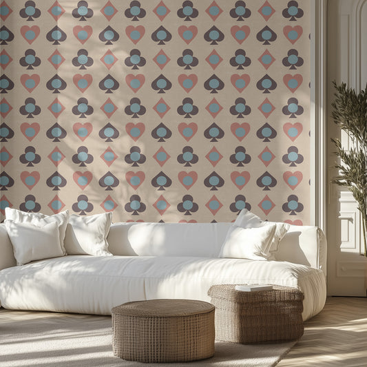 Modern living room with a white sofa, wicker ottomans, and playing card patterned, textured wall.