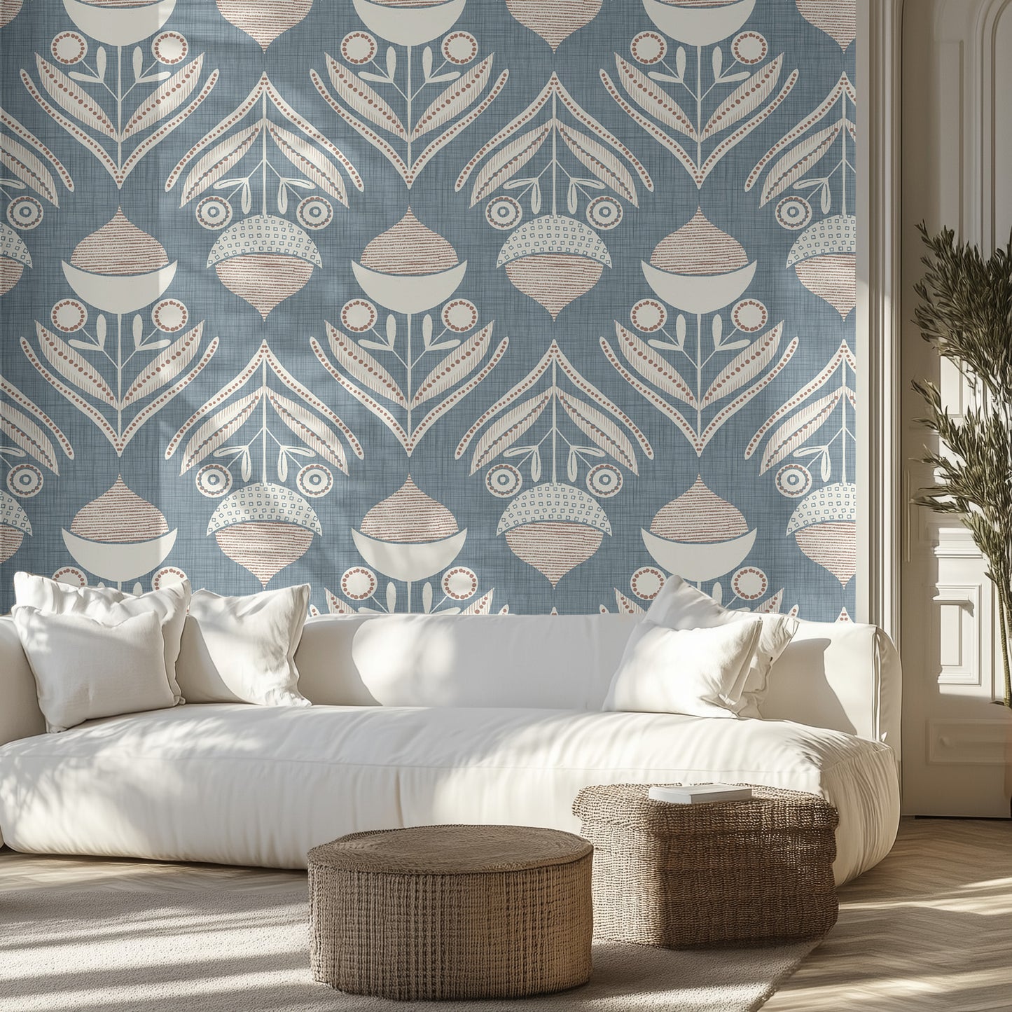 Living room with a blue and cream textured patterned wall, white sofa, and decorative ottomans.