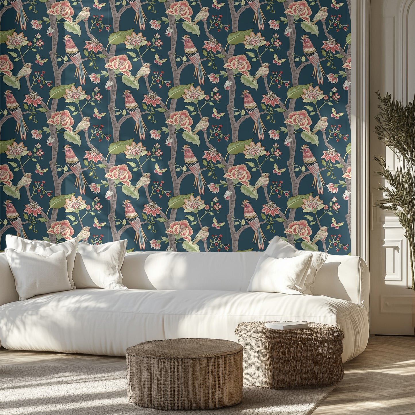 Living room with floral and bird patterned wallpaper, white sofa, and wicker ottomans.