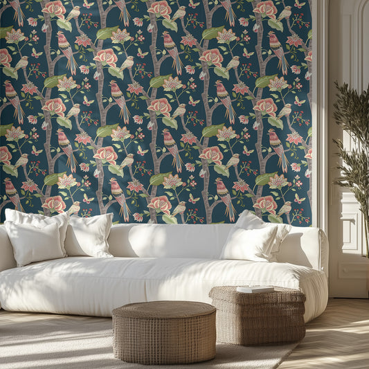 Living room with floral and bird patterned wallpaper, white sofa, and wicker ottomans.