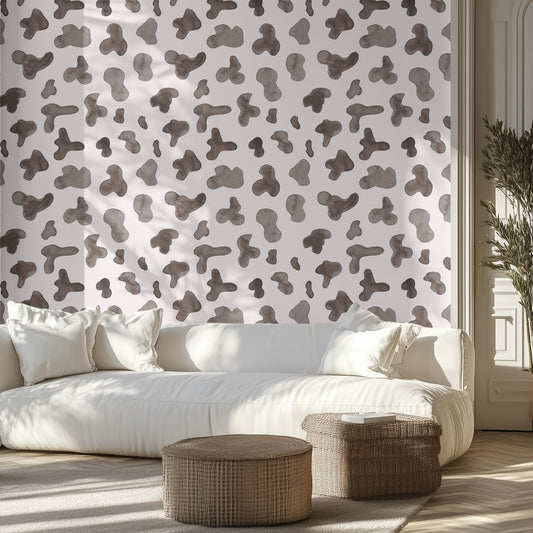 Living room with a white sofa, cow hide patterned wall, and wicker ottomans.