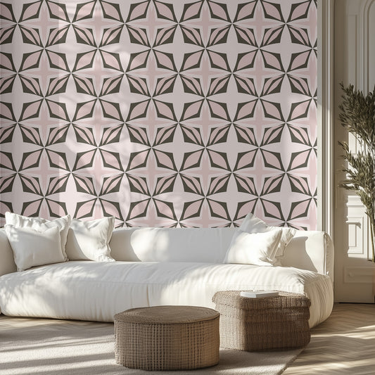 Living room with geometric soft pink and muted green diamond patterned wallpaper, white sofa, and wicker ottomans.