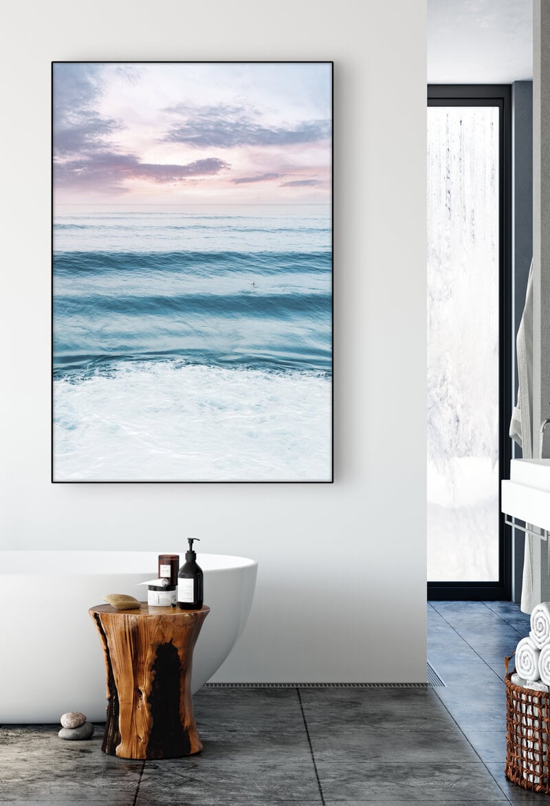 Blue wave wall art hangs in bathroom above soaking tub creating a peaceful, spa-like feel.