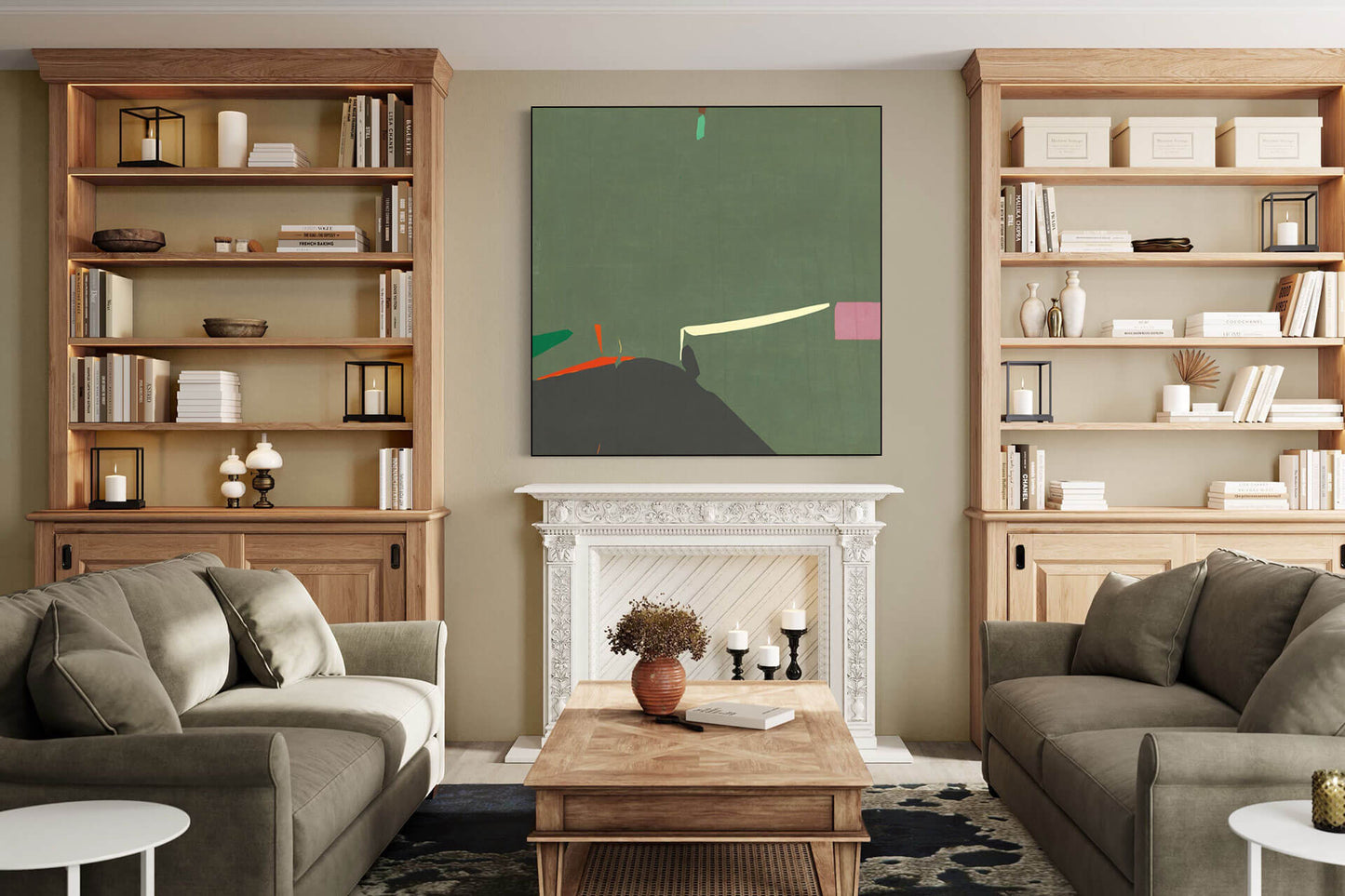 Large square abstract art in sage green hangs above fireplace and between bookcases in living room.