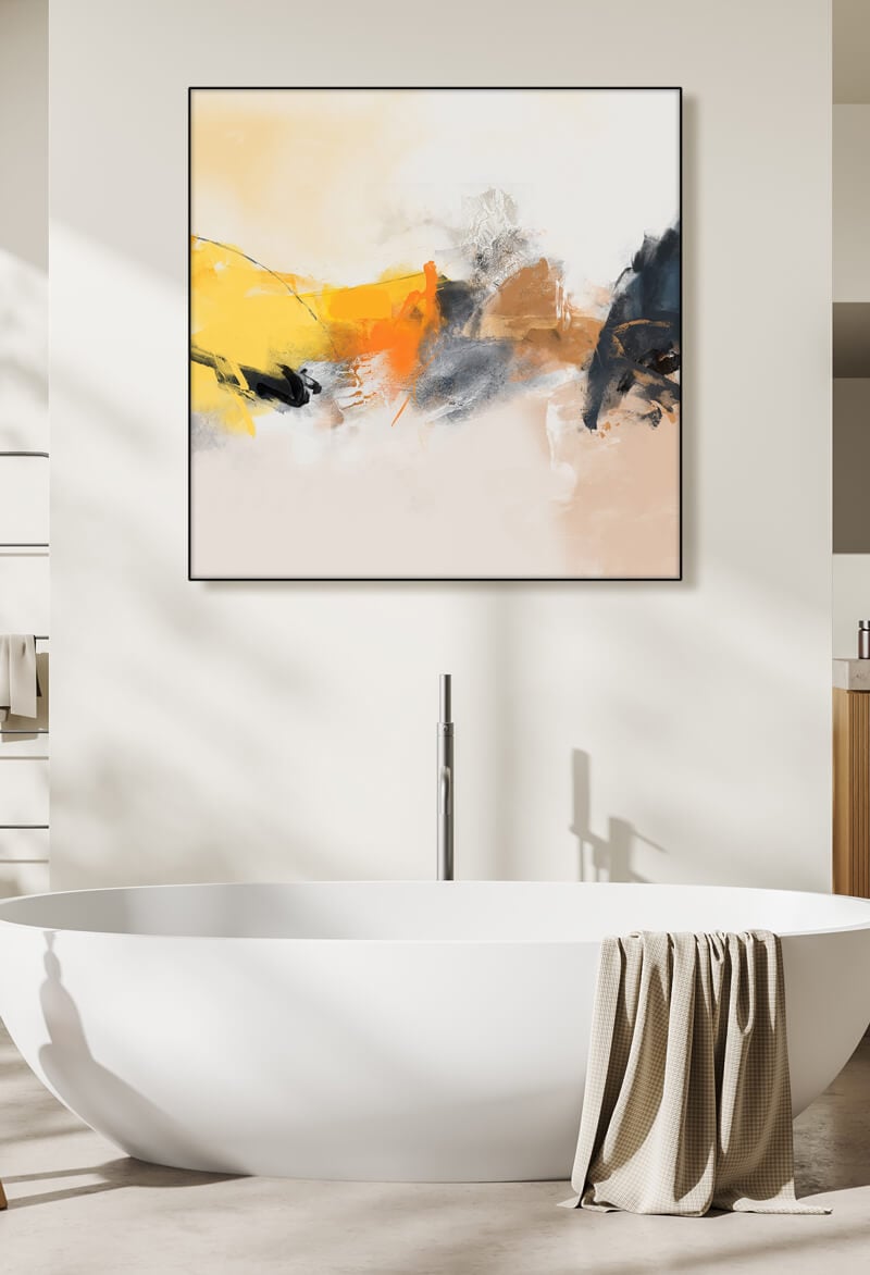 Square neutral abstract wall art in yellow, orange, and tan hangs above white soaking tub in modern bathroom.