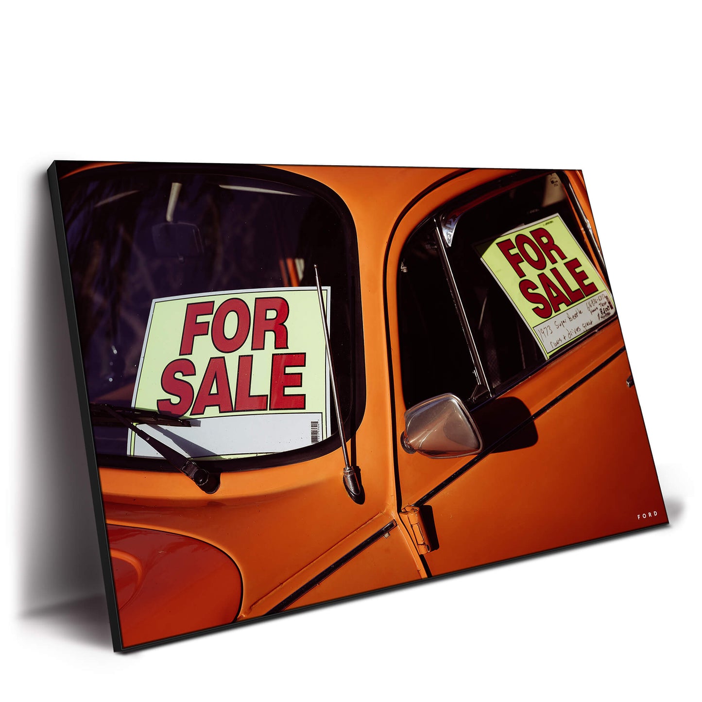 Vintage orange beetle car with 'For Sale' signs in the windows.