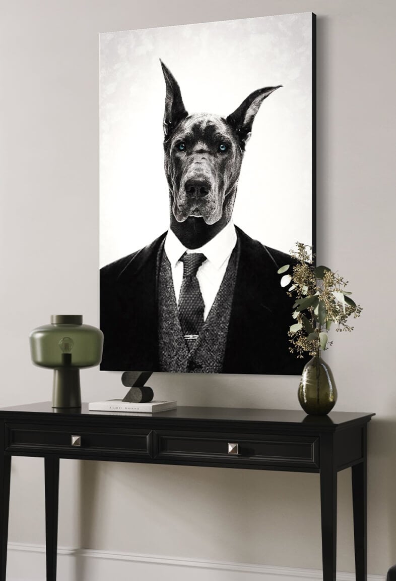 Huge black and white photo of black Great Dane wearing black and white suit hangs above black console table in modern home's entryway