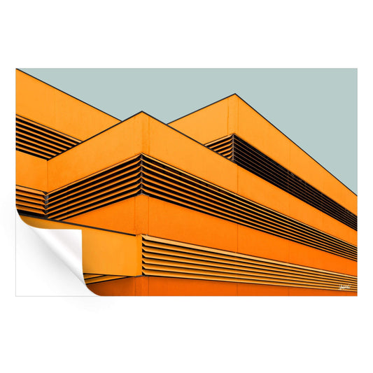 Building facade with orange panels and black slats in a pattern against a gray-blue background.