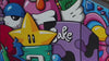 A busy, multi-colored mural wall painted with a dense collection of cartoon characters, including a star with eyes, a purple monster, and a yellow mouse.