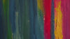 Colorful abstract painting with layered vertical brushstrokes in blue, green, red, and gold tones.