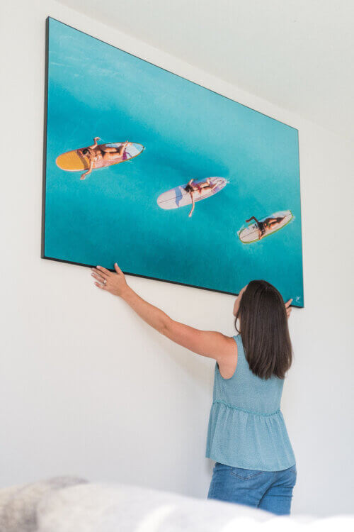 Extra large aerial surfer girl wall art being hung in living room