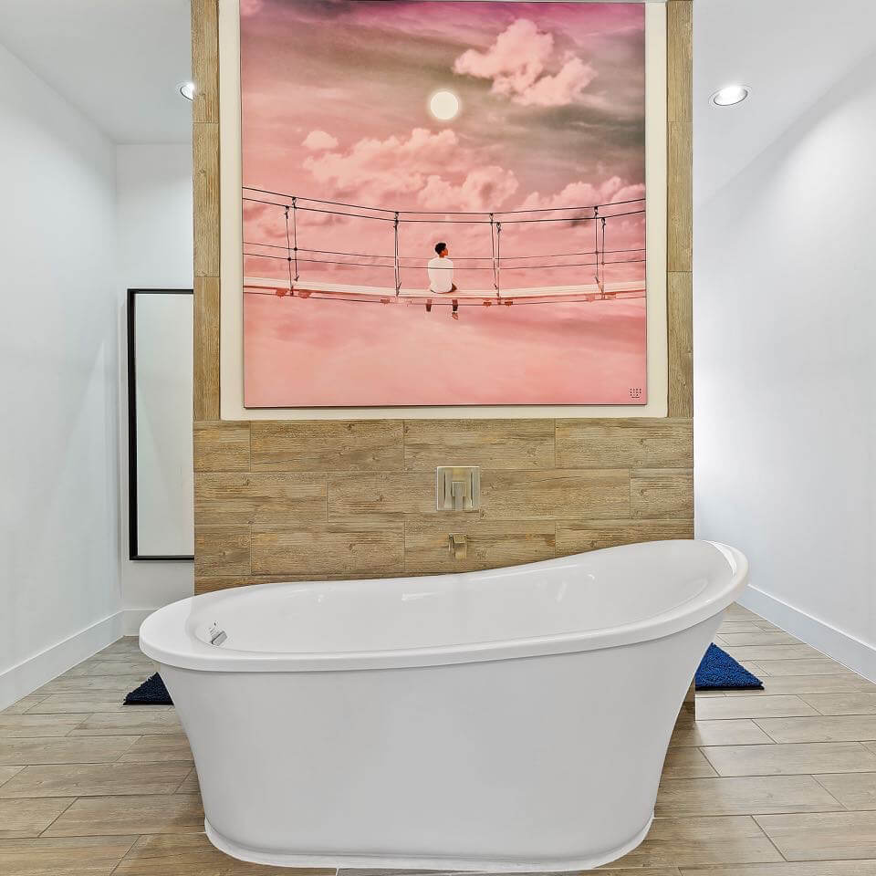 Massive pink artwork hung on feature wall in bathroom above freestanding tub