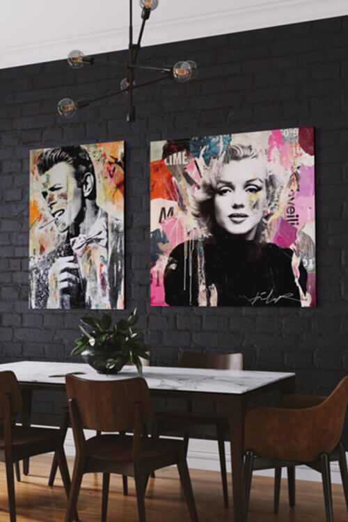 Pop singer wall art featuring David Bowie and Marilyn Monroe hang side by side on black brick wall in modern dining room