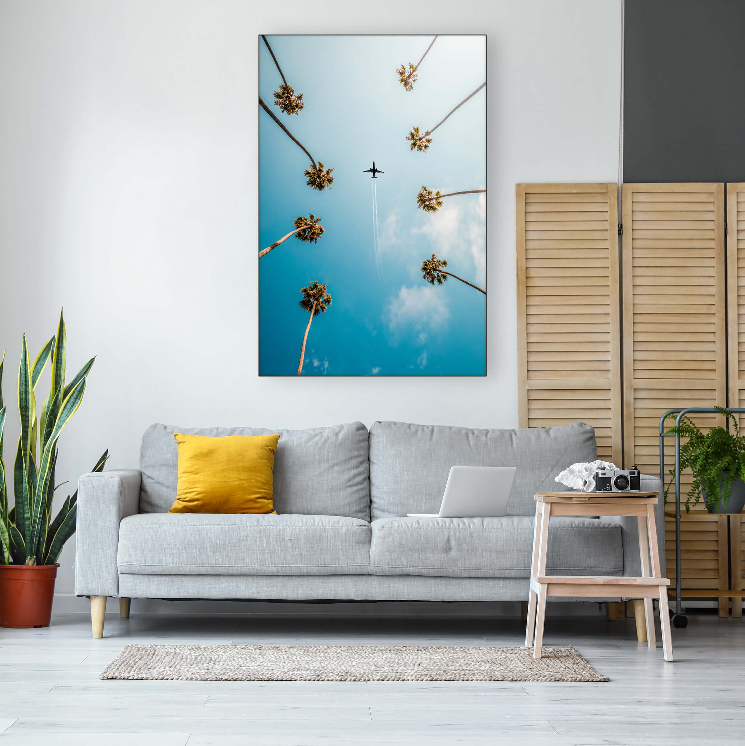 Huge vertical photo of plane flying between two rows of palm trees hangs in neutral living room