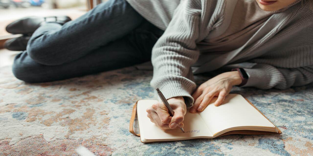 a person writing down inspired thoughts in a journal