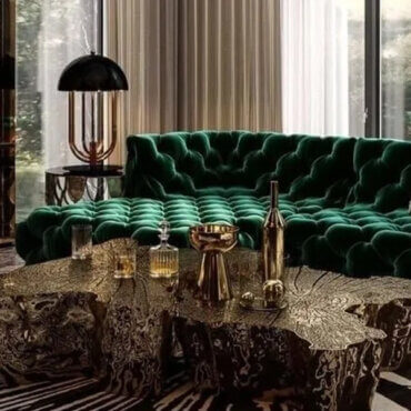 Dark luxury living room with emerald green velvet sofa, gold decor, and organic wood coffee table.