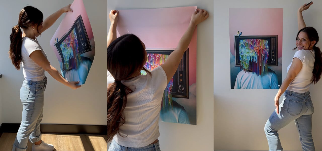 College student hanging colorful peel and stick wall art in dorm or apartment
