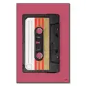 Close-up of a vintage black audio cassette tape with retro gold and red stripes on the label against a muted pink background.