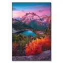 Scene in the North Cascades, Washington, featuring rugged peaks, an alpine lake, and vibrant autumn foliage under a pink twilight sky.