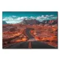 Winding road through the Valley of Fire in Nevada, with rugged mountains and a turquoise sky.