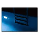 A blue pool at night, softly illuminated with reflections on the water.