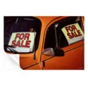 Vintage orange beetle car with 'For Sale' signs in the windows.