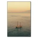 A sailboat on calm waters during a sunset in Italy.