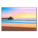 The Manhattan Beach Pier during sunset, with vibrant colors reflecting on the water, creating a serene beach atmosphere.