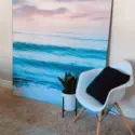 Large square wave wall art leaned up against a wall in neutral living room