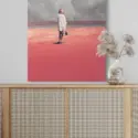 Huge pink surreal artwork of woman in pink sand desert looking at man in distant storm of clouds hangs on white wall in modern boho living room