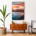 Extra large vertical photo of beach at sunset with vibrant colors hangs in boho living room above wooden side table