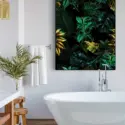 Huge green bathroom wall art featuring tropical plant leaves hangs above white soaking tub.