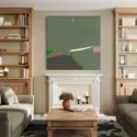Large square abstract art in sage green hangs above fireplace and between bookcases in living room.