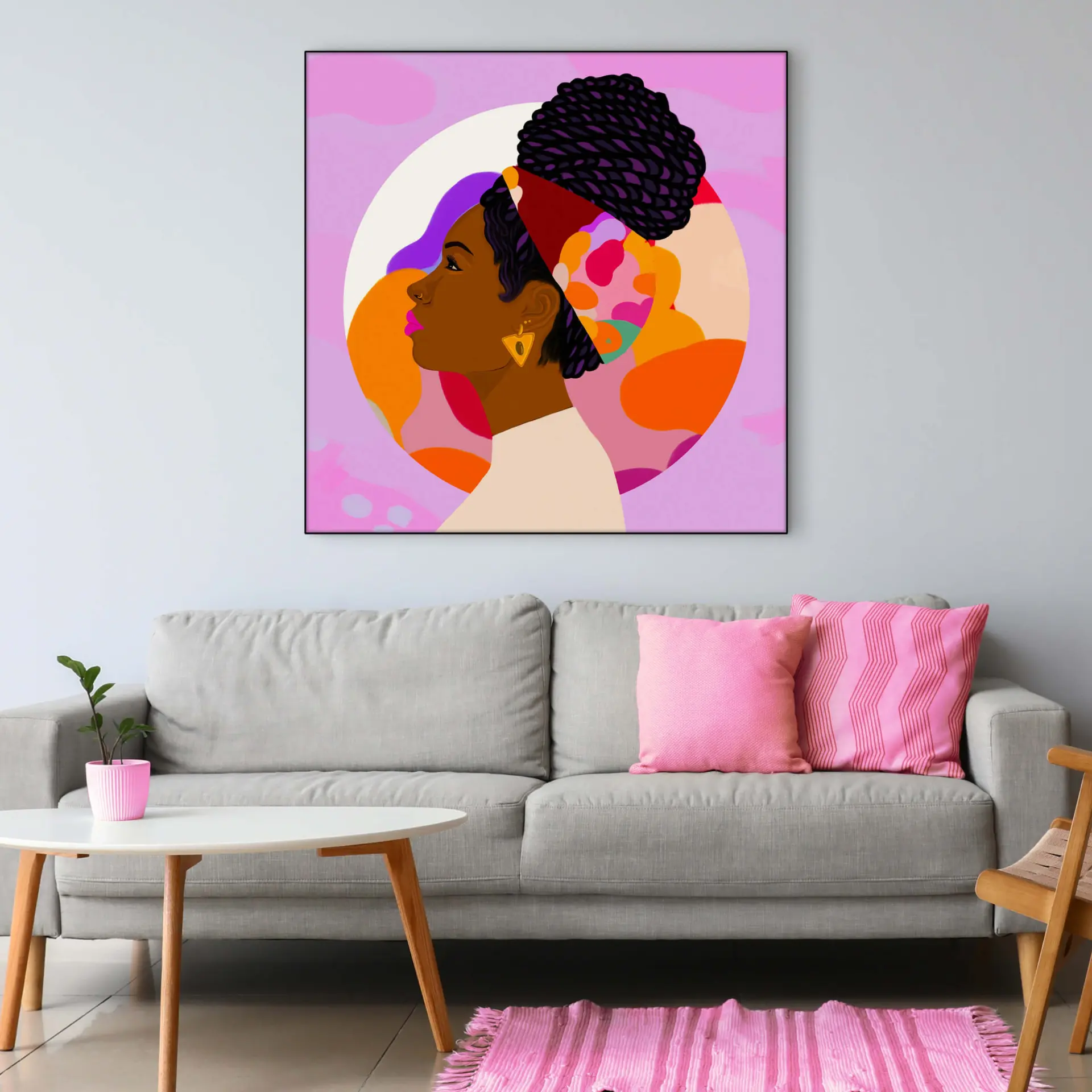 Pink wall art featuring Black Queen profile hangs on neutral wall in living room.