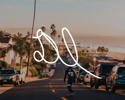 Photo of skater riding down road next to beach with Deston Isas signature in white