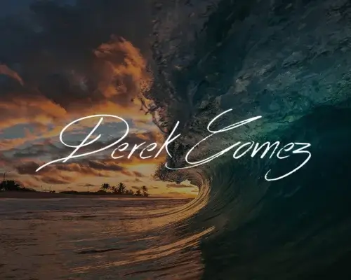 Ocean wave photography as wave just started to crash at sunset with photographer Derek Gomez signature in white