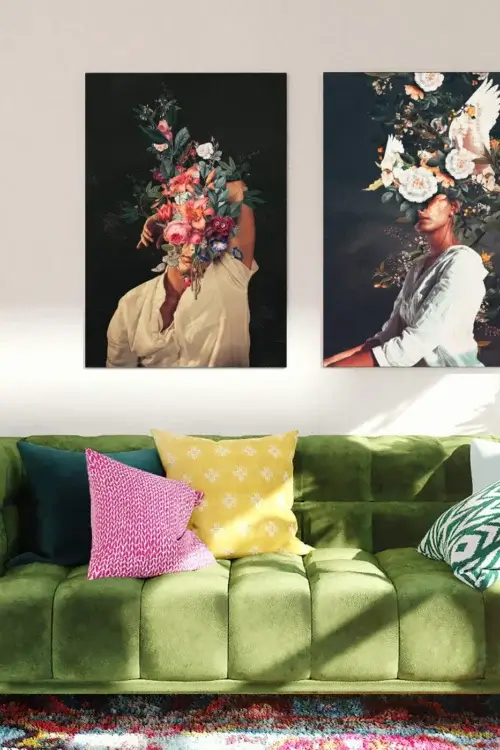 Two Frank Moth Floral Head Large Wall Art Pieces Hang Side by Side Above Green Couch in Living Room